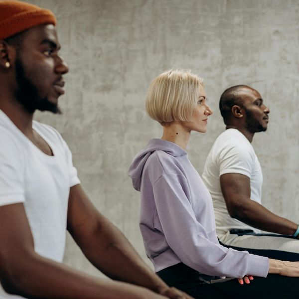 A diverse group of women practicing a gentle yoga stretch together.