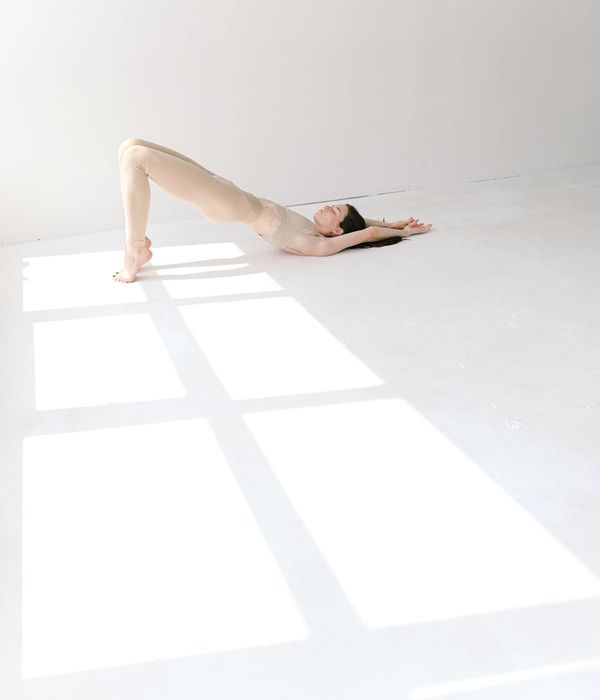 Woman in a calm yoga pose in a bright, serene studio environment.